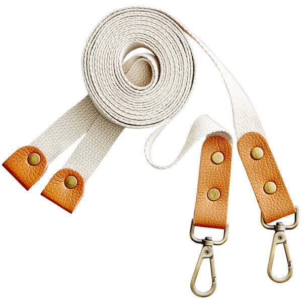 A pair of cream-colored cross-back replacement straps with tan leather accents and metal clips.