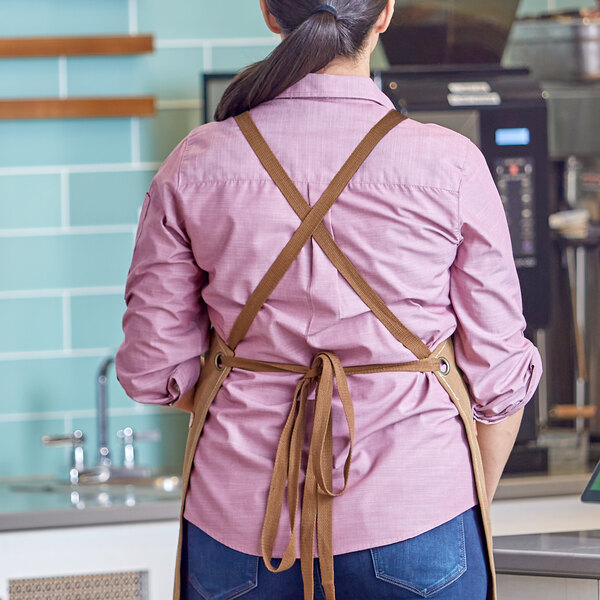 A pair of mocha-colored cross-back replacement apron straps shown tied on a person from the back.