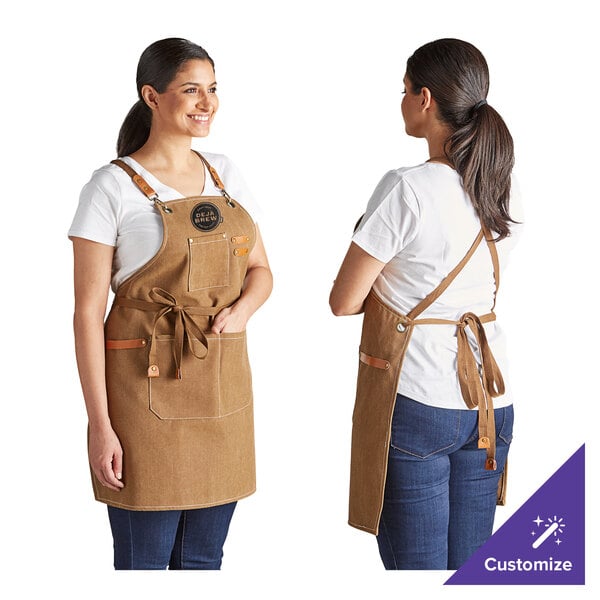 A customizable mocha-colored heavy weight canvas cross-back bib apron with three pockets, shown from the front and back.