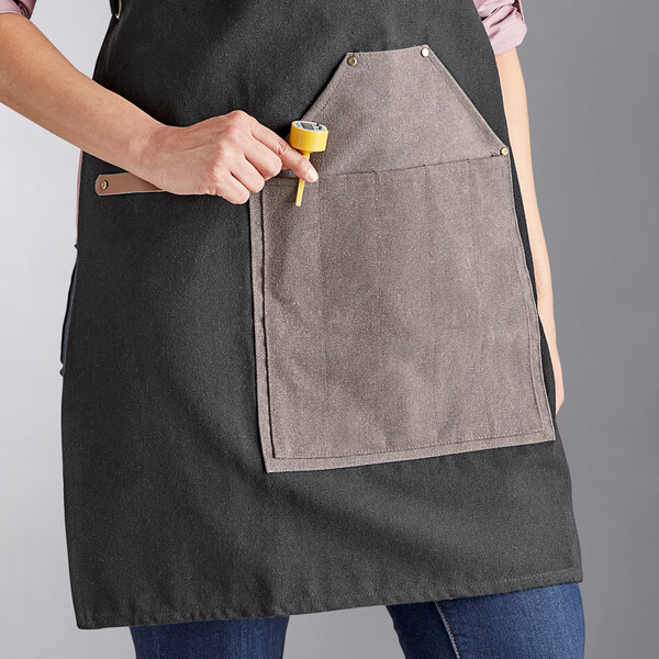 A charcoal heavy-duty canvas grilling apron with a large utility pocket on the front.
