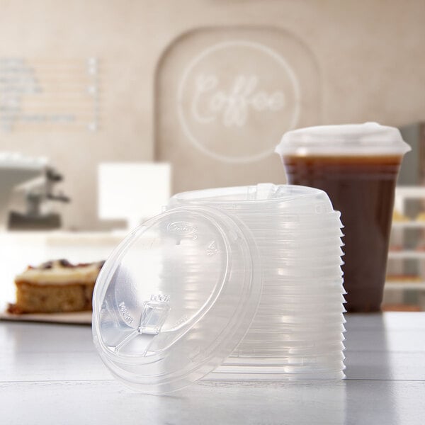 A stack of clear polypropylene reclosable strawless lids for 12-26 oz cups.