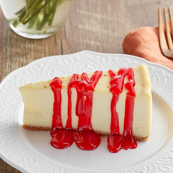 A slice of cheesecake topped with strawberry sauce on a white plate.