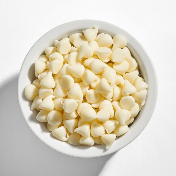 A white bowl filled with Nestle Toll House Premier White morsels.