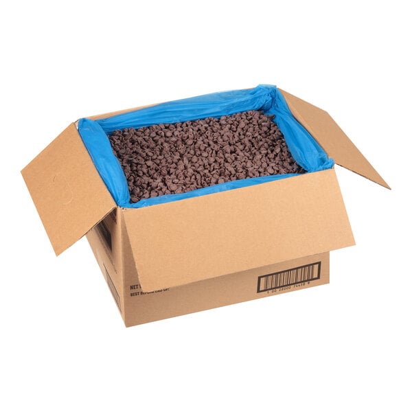A large open cardboard box lined with a blue plastic bag and filled with semi-sweet chocolate morsels.