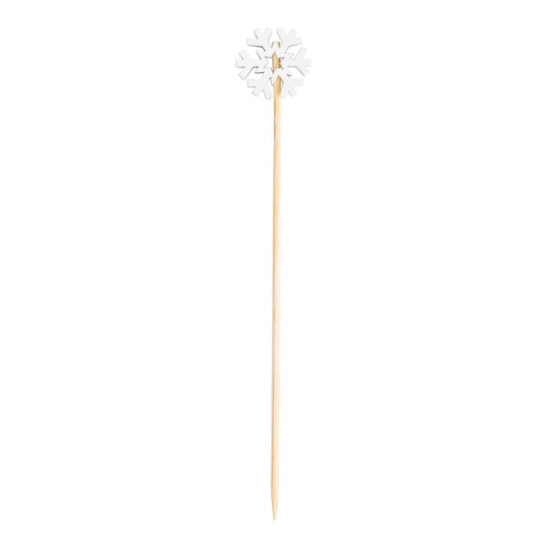 A bamboo cocktail pick with a decorative white snowflake at the top.