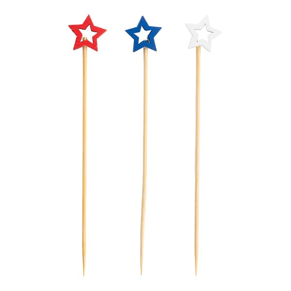 A set of three bamboo cocktail picks with red, blue, and white star-shaped tops.