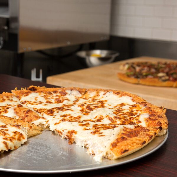 A pizza on an American Metalcraft pizza tray.