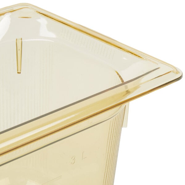 A Vollrath amber plastic food pan on a counter.