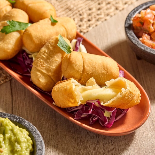 A plate of mini cheese tequeños, which are fried dough sticks filled with cheese.