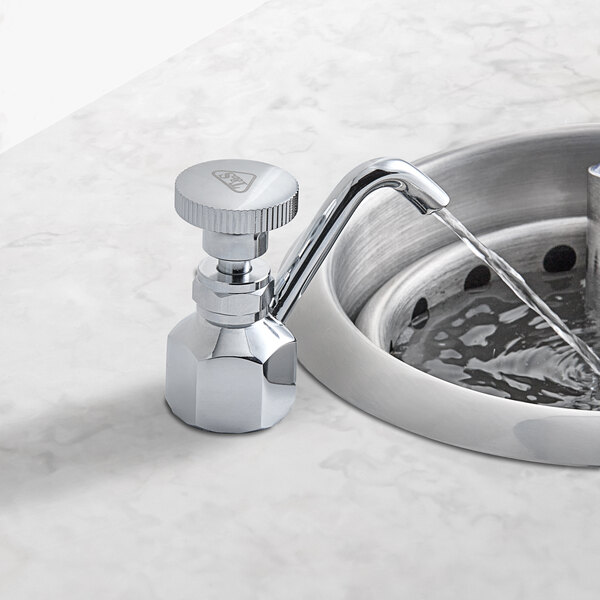 A T&S B-2282-F03 Flow Control faucet running water into a sink.