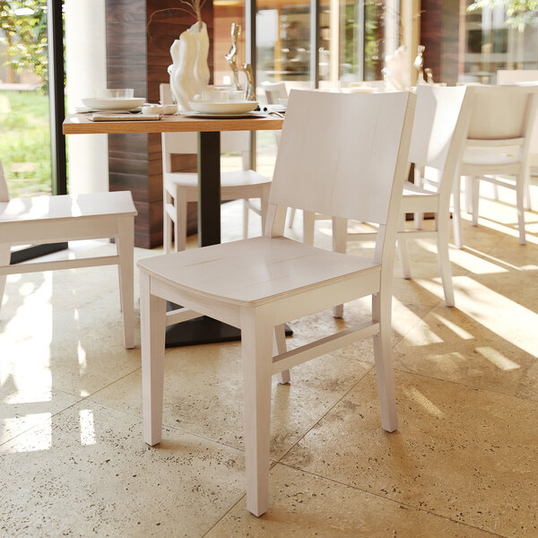 A white solid wood dining chair with a simple, modern design.