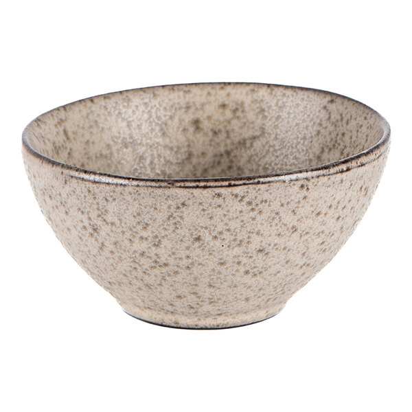 A round tan stoneware tea cup with a speckled texture.