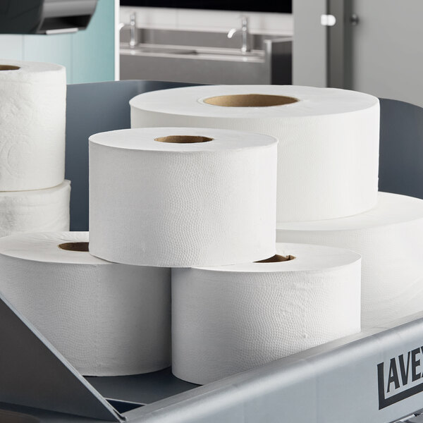 A set of large white 2-ply toilet paper mega rolls displayed in a commercial setting.