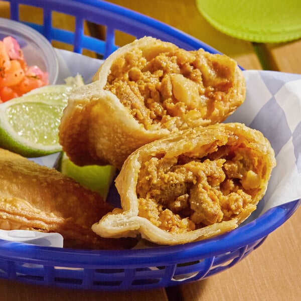 An empanada with a flour shell filled with Spanish chorizo, served in a blue basket.