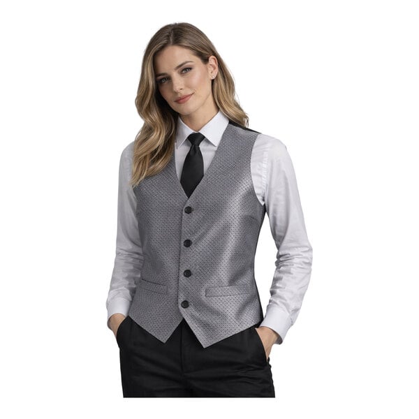 A women's silver brocade diamond pattern server vest with black buttons, worn over a white shirt and black tie.