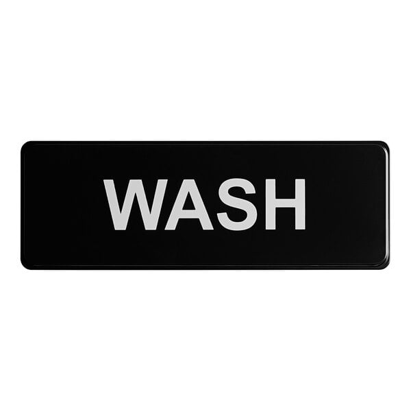 A rectangular black sign with the word 'WASH' in white capital letters.