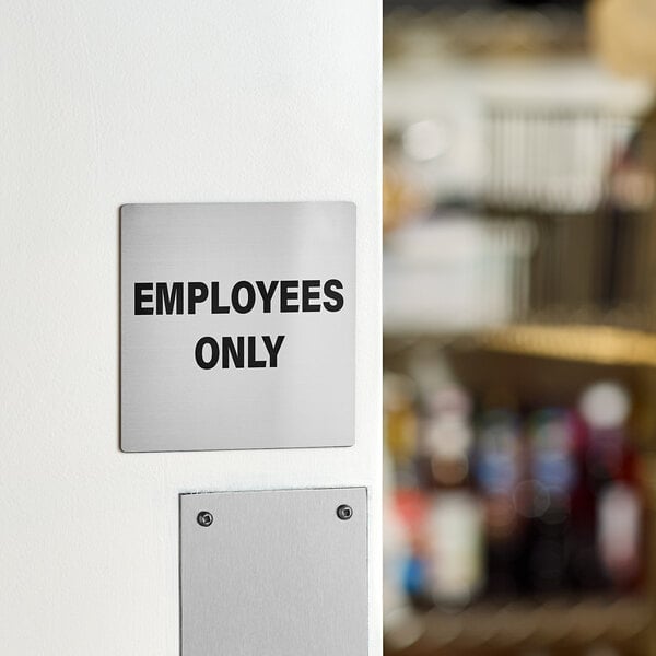 A square stainless steel sign with the text 'EMPLOYEES ONLY' in black letters.
