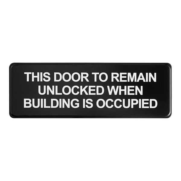 A rectangular black and white sign that reads 'This Door To Remain Unlocked When Building Is Occupied.'
