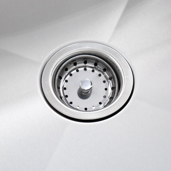 A close-up of a stainless steel sink drain with a strainer.