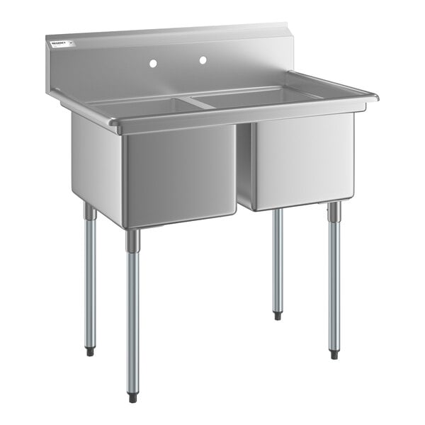 A stainless steel two-compartment sink with four metal legs and a backsplash, designed for commercial use.