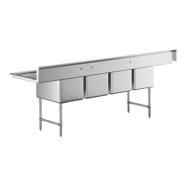 A large stainless steel commercial sink with four deep compartments and two side drainboards, supported by metal legs.