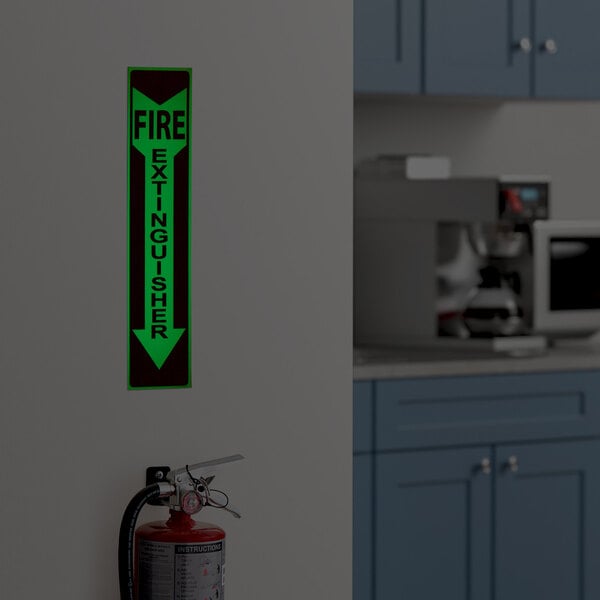 A glow-in-the-dark adhesive vinyl safety label with a down arrow and the words 'Fire Extinguisher' in red and white.