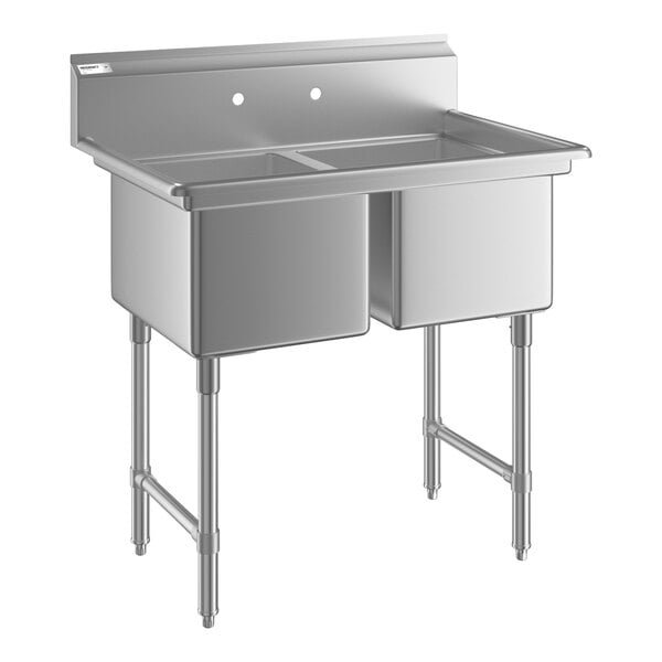 A stainless steel two-compartment sink with four legs and a backsplash, featuring two deep rectangular basins.