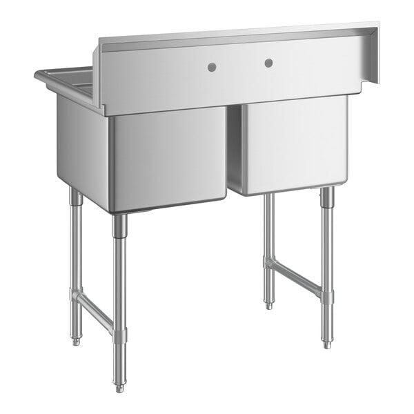 A stainless steel two-compartment sink with four legs and a high backsplash featuring two faucet holes.