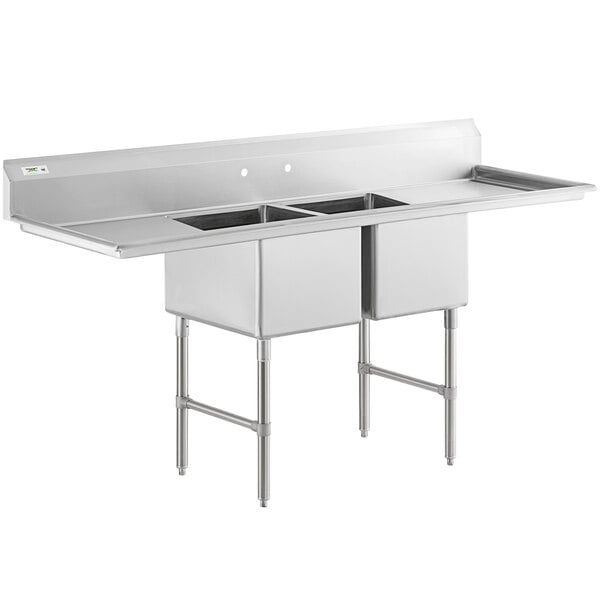 A large stainless steel two-compartment commercial sink with two drainboards, stainless steel legs, and cross bracing.