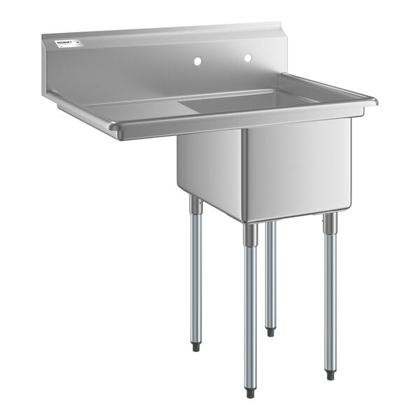 A stainless steel commercial sink with four metal legs, a single deep basin, a left-side drainboard, and a backsplash with two faucet holes.