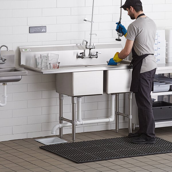 A stainless steel two-compartment commercial sink with an 18-inch left drainboard, stainless steel legs, and cross bracing.