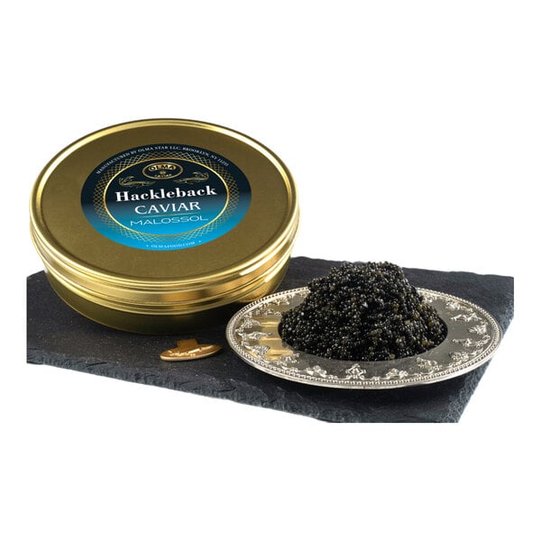 A tin of OLMA Hackleback Caviar with a serving of caviar on a decorative plate.
