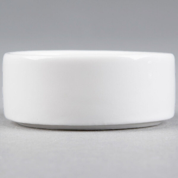 A small, round, white porcelain salt and pepper dish.