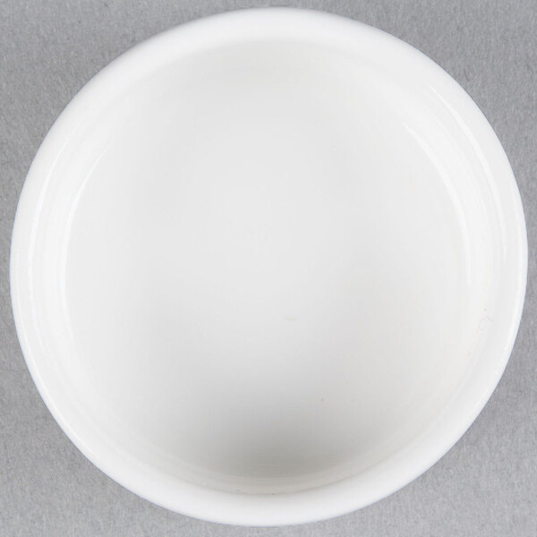 A small, round, white porcelain salt and pepper dish.