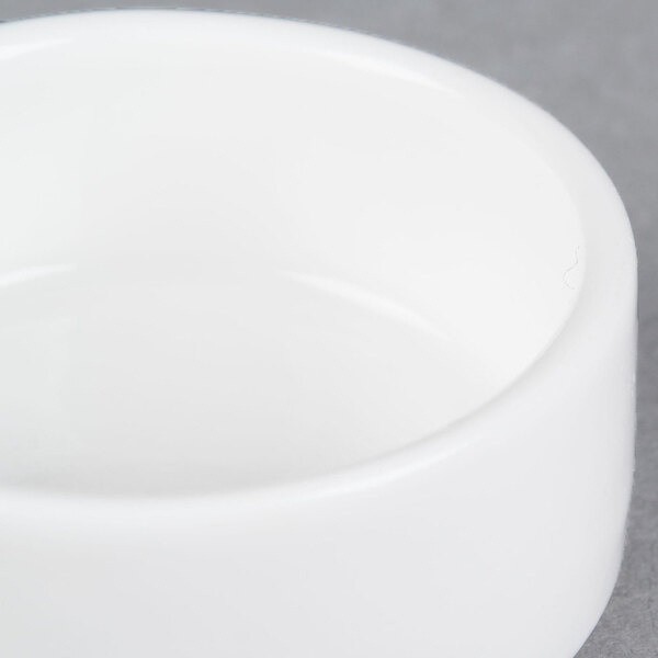 A small, round, white porcelain salt and pepper dish.