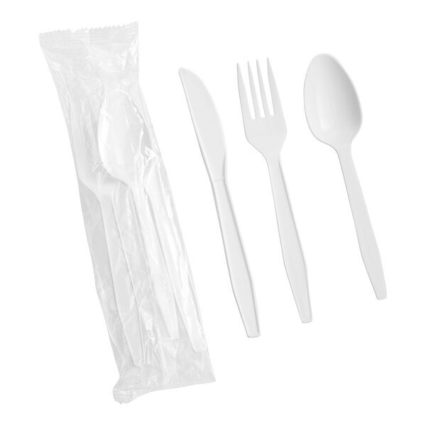 A set of white heavy weight plastic cutlery including a knife, fork, and spoon, with one set shown individually and another set packaged in plastic.