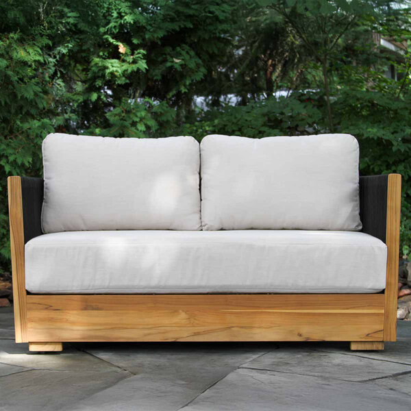 A wooden outdoor love seat with black rope sides and light-colored Sunbrella cushions.