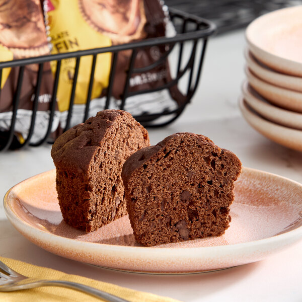 A gluten-free chocolate muffin cut in half and served on a plate.