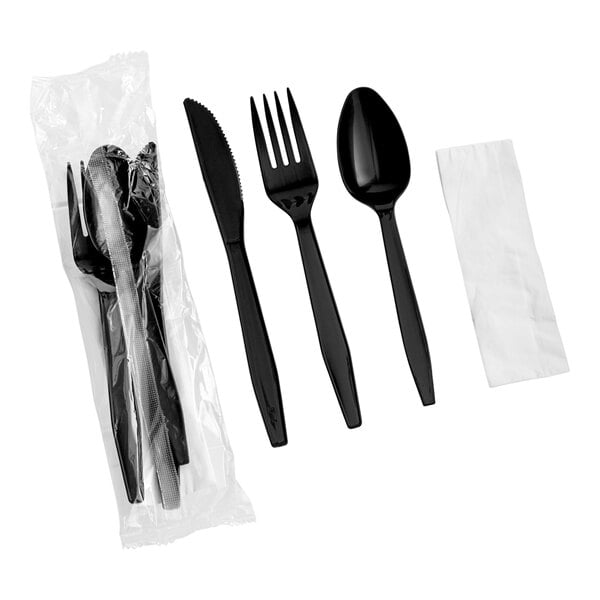 A set of black heavy weight plastic cutlery including a knife, fork, spoon, and a napkin, with additional sets packaged in plastic.