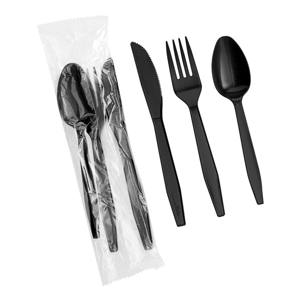 A set of black heavy weight polypropylene plastic cutlery including a knife, fork, and spoon, with one set individually wrapped in plastic.