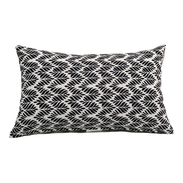 A rectangular lumbar pillow with a black leaf pattern on a white background.