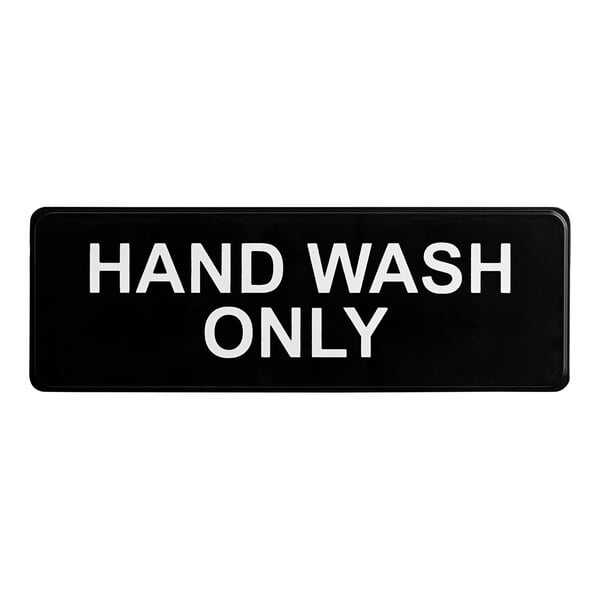 A rectangular black and white plastic sign with the text 'Hand Wash Only.'