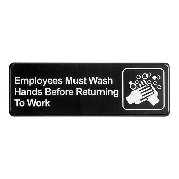 A rectangular black and white plastic sign that reads 'Employees Must Wash Hands Before Returning To Work' with a handwashing graphic.