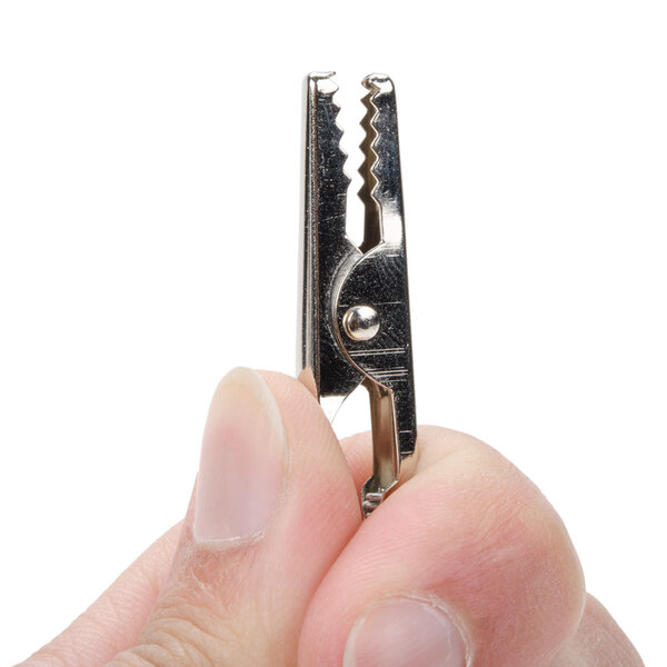A small metal alligator clip being held between two fingers.