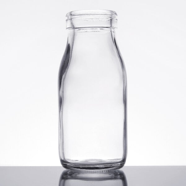 A clear 6 oz. glass milk bottle with a narrow neck and wide base.