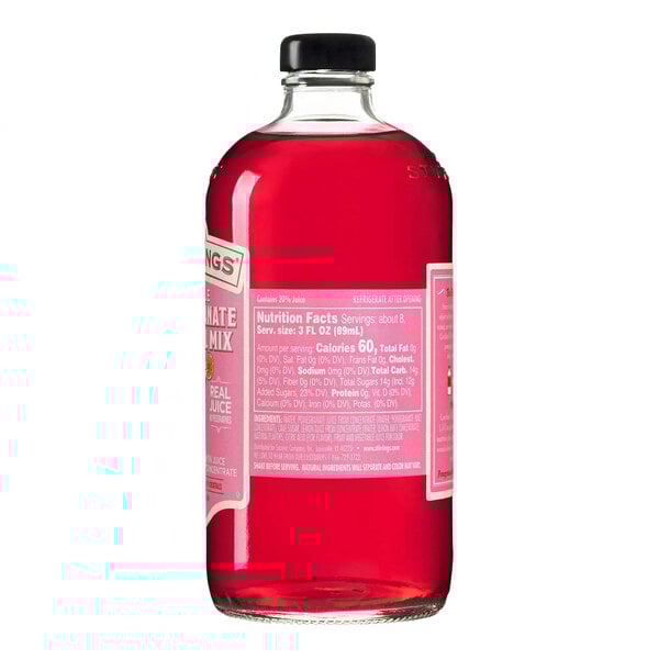 A clear glass bottle filled with bright red pomegranate cocktail mix and sealed with a black cap.