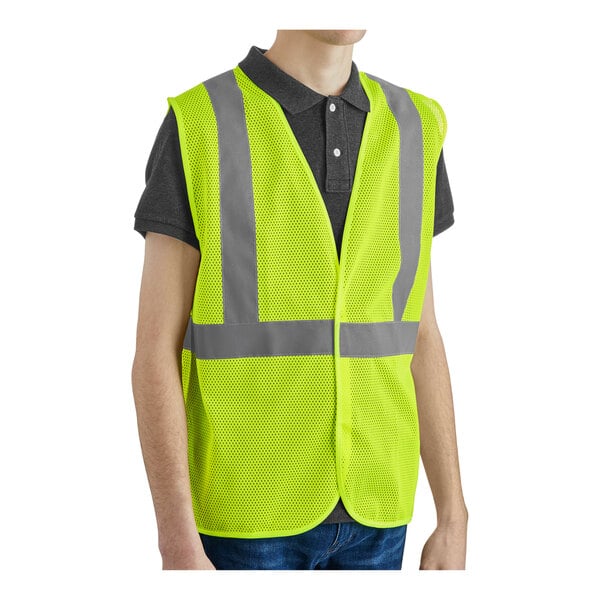 A lime high visibility safety vest with reflective stripes and a hook and loop closure.