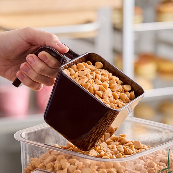 A brown polycarbonate portion scoop filled with butterscotch chips.