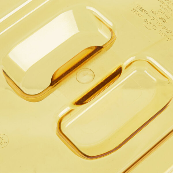 A close up of a yellow Vollrath plastic slotted cover with two holes.