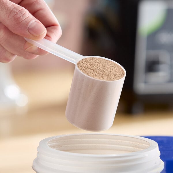 An 80 cc polypropylene scoop with a medium handle being used to measure powder.